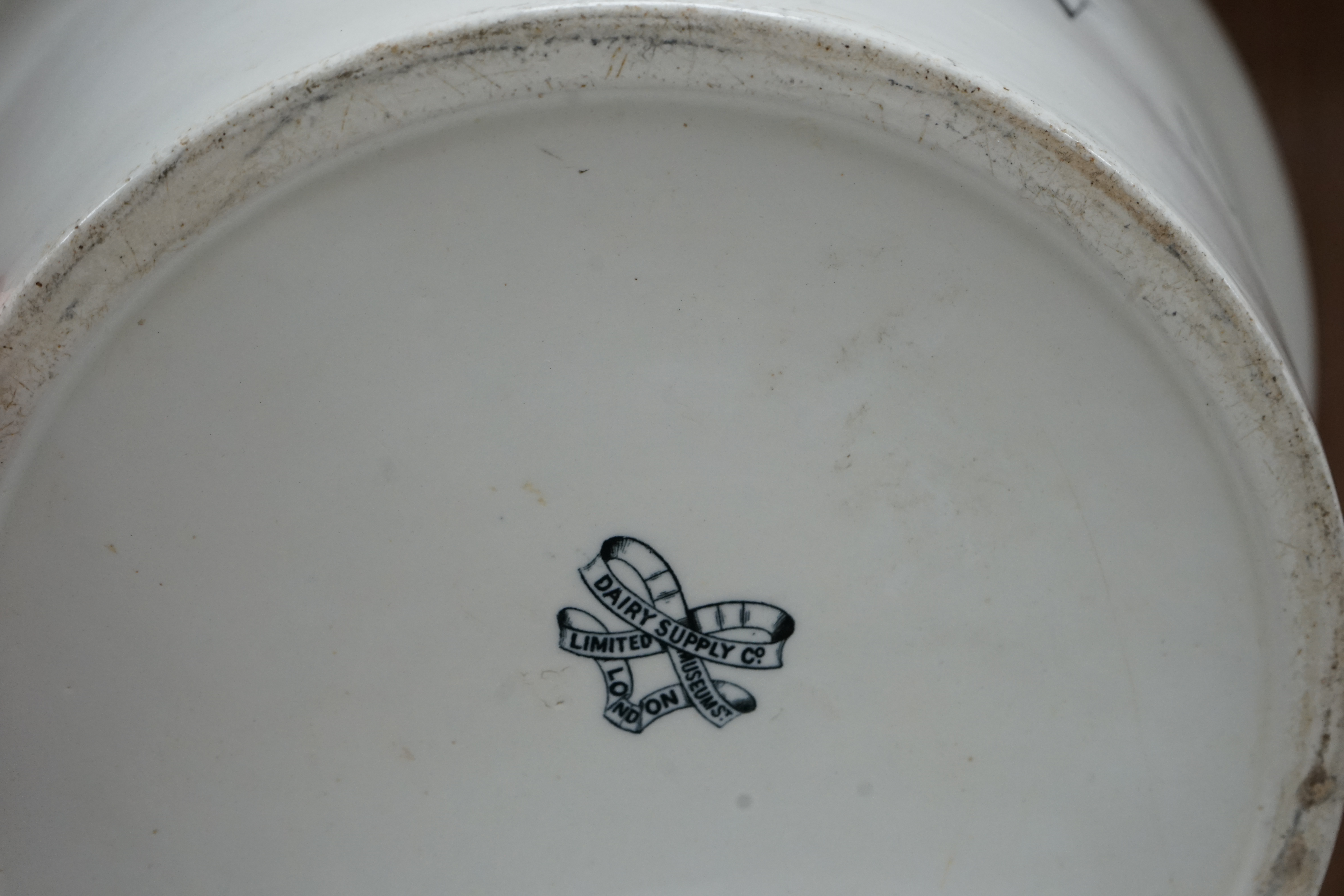 A Dairy Supply Co. Ltd 'New Milk' cream glazed dairy bowl, 34cm diameter. Condition - some marks to top edge of bowl.